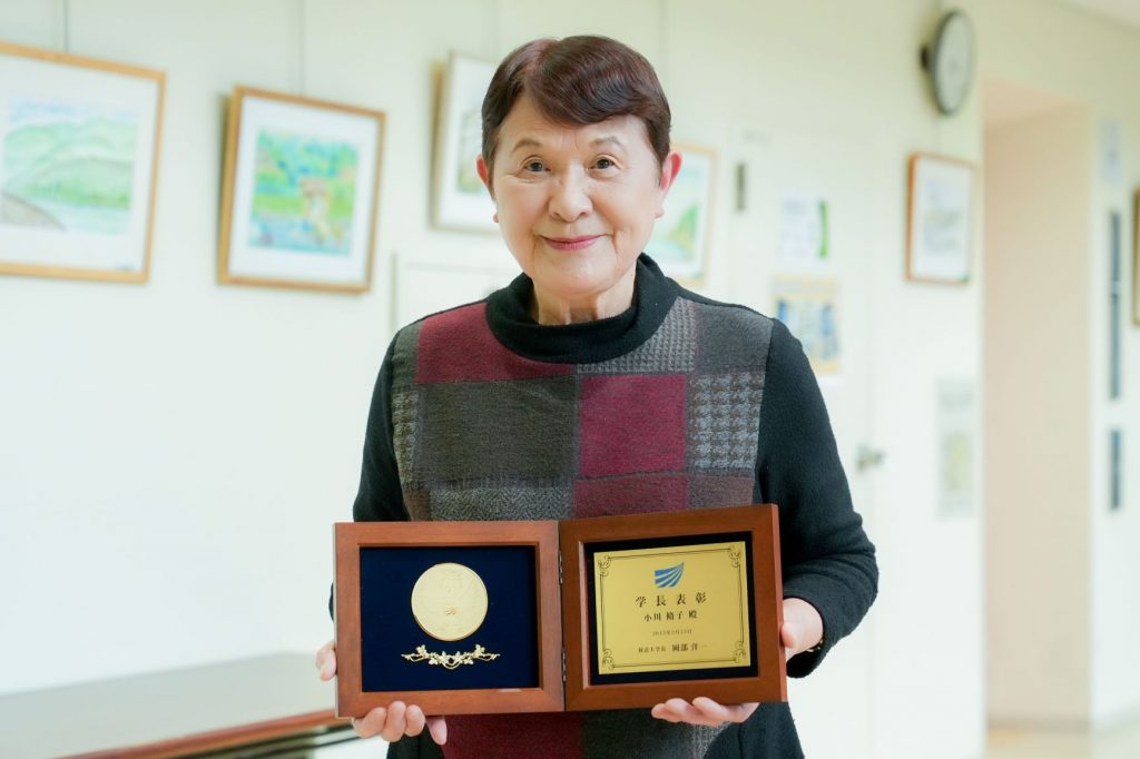 学長表彰のメダルを持つ小川 脩子さんの写真