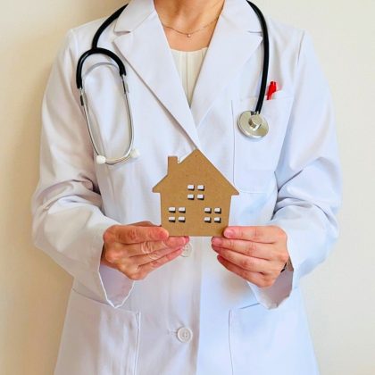 家の模型を持った女性医師の写真