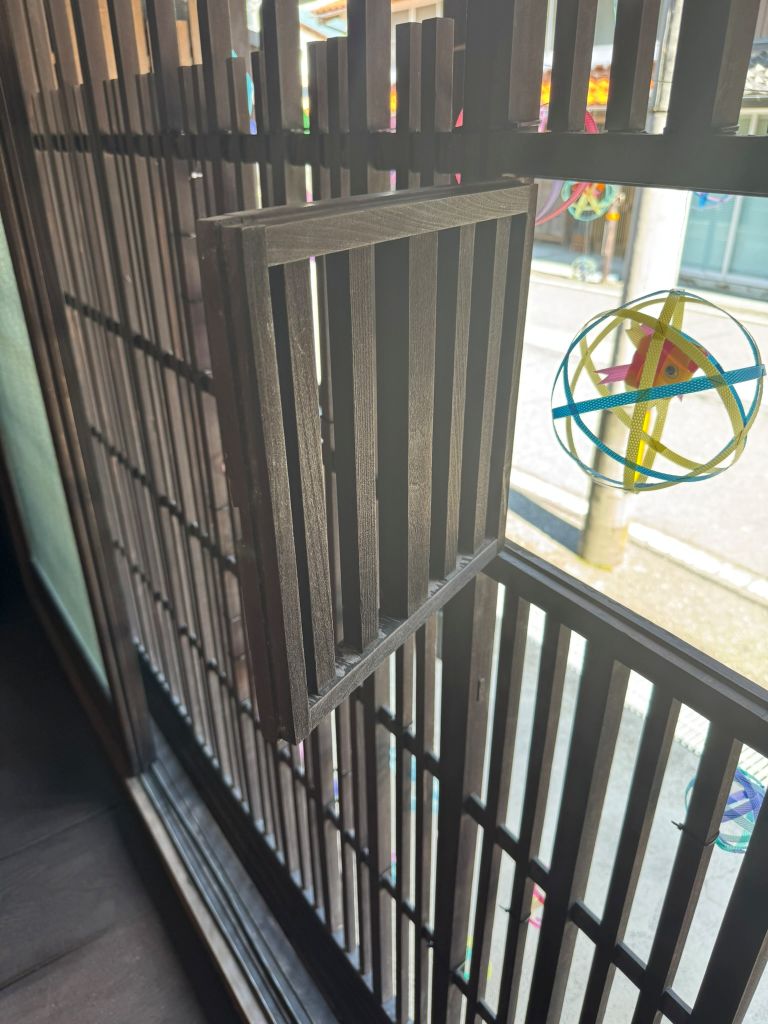 【木連格子(きづれこうし)】 ふるいみんかのかいどうがわにめんしてつくられたまどがわりのこうしでそのちいさないちぶがうちがわにひらくことができるようになっています