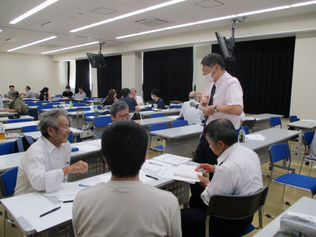 講師がグループ学習中の学生にアドバイスしている写真
