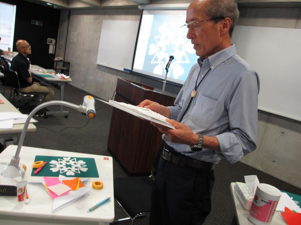 講師が作品例を投影して「表現」について講義している写真
